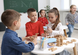 three children working on a table activity together