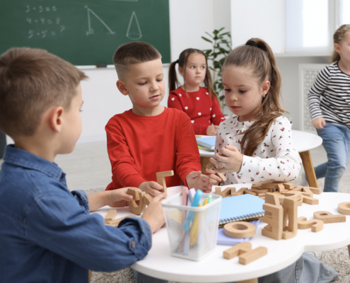 three children working on a table activity together