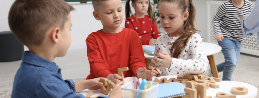 three children working on a table activity together