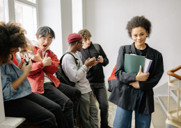 A group of teenagers at the top of a stairwell in a college