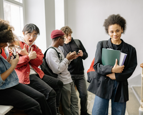 A group of teenagers at the top of a stairwell in a college