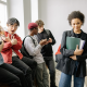 A group of teenagers at the top of a stairwell in a college