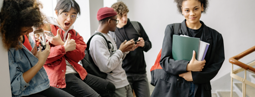 A group of teenagers at the top of a stairwell in a college