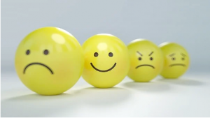 a line of yellow balls each with a different facial expression drawn on them