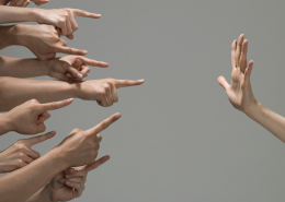 many hands pointing at a hand opposite that is facing palm towards them.