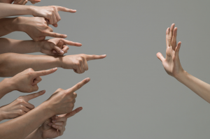 many hands pointing at a hand opposite that is facing palm towards them. 