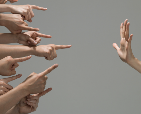 many hands pointing at a hand opposite that is facing palm towards them.