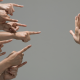 many hands pointing at a hand opposite that is facing palm towards them.