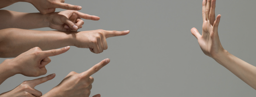 many hands pointing at a hand opposite that is facing palm towards them.