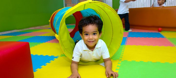 Young child climbing through a play tunnel