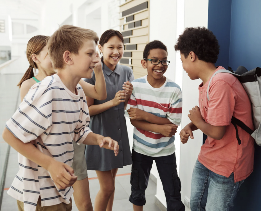 three boys and two girls in a school playground 