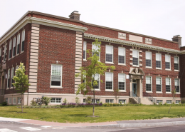 Large school building with red and pale bricks.
