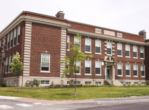 Large school building with red and pale bricks.