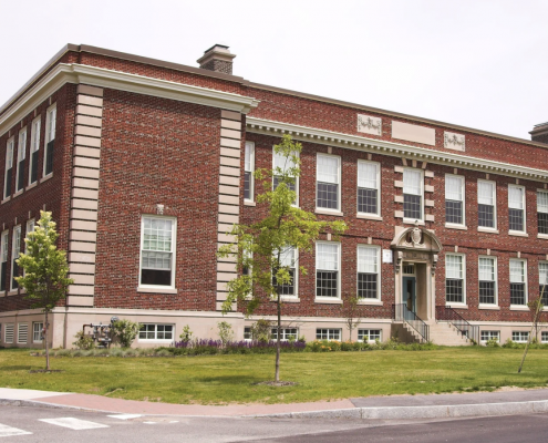 Large school building with red and pale bricks.