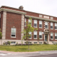 Large school building with red and pale bricks.