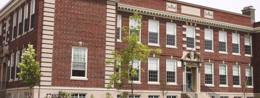 Large school building with red and pale bricks.